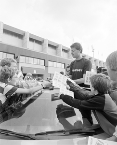 885052 Afbeelding van kinderen die een handtekening vragen aan een speler van FC Utrecht die staat in een luxe bolide, ...